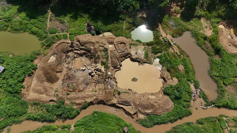 Aerial view of a small-scale mining site among green farmland and streams